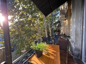 Una mesa de madera en un balcón con un árbol. en Lola Apartments, en Tiflis