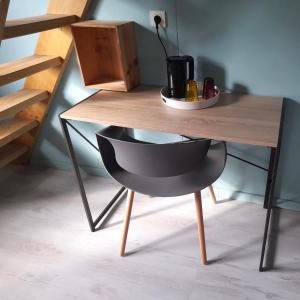 a wooden table with a black chair under it at A 3 mn à pied du lagon... Chambre Cardinal in Étang-Salé les Bains