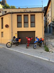 Hotel 9 Sant Antoni في ريب دي فريزر: ثلاث دراجات نارية متوقفة أمام مرآب
