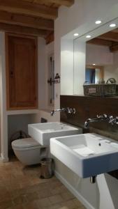 a bathroom with two sinks and a toilet and a mirror at La Ruette aux Loups in Collonges-au-Mont-dʼOr +40 photos