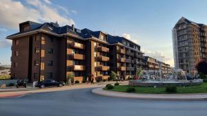 un grande edificio con una fontana di fronte di Apartman Oaza Kalman SPA-GYM a Zlatibor