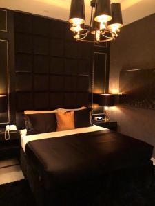 a bedroom with a large bed with a black headboard at Dana Hotel & Residences 2 in Riyadh