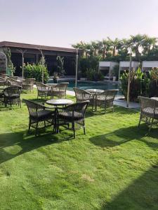 un groupe de tables et de chaises sur l'herbe dans l'établissement Dana Hotel & Residences 2, à Riyad