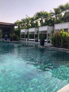una piscina con agua turquesa y palmeras en Dana Hotel & Residences 2 en Riad
