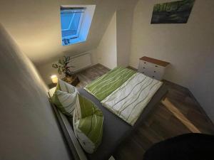 a bedroom with a bed with green sheets and a window at Ferienwohnung Sonnenhof 