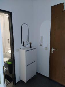 biała łazienka z lustrem i umywalką w obiekcie B006 Schöne, helle Ferienwohnung w mieście Lahnstein