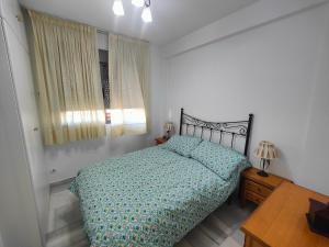 Schlafzimmer mit einem Bett, einem Tisch und einem Fenster in der Unterkunft GRAN APARTAMENTO CERCA DE LA PLAYA CON PISCINA en EL CENTRO in Fuengirola
