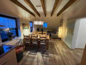 una sala da pranzo e un soggiorno con tavolo e sedie di Ferienwohnung Sonnenhof a Ammelsdorf