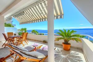 eine Terrasse mit Stühlen und einem Tisch auf dem Balkon in der Unterkunft Apartments Meri in Trogir
