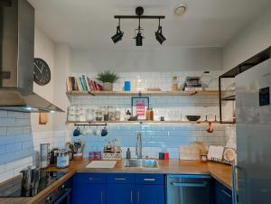 a kitchen with blue cabinets and a sink at Spacious, Mid-Century 1 bedroom Apartment in Quedgeley