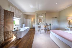 a bedroom with a bed and a tub and a sink at The Packhorse Inn in Newmarket