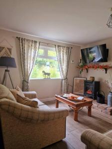 a living room with a couch and a table at Beech Tree Cottage 