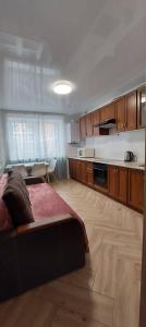 a bedroom with a large bed and a kitchen at Апартаменти Класик у ЖК Яровиця in Lutsk