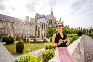 a woman holding a camera in front of a building at Les Bulles Blanches in Avize