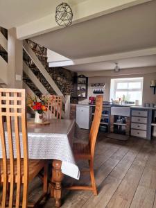 cocina y comedor con mesa y sillas en Beech Tree Cottage 