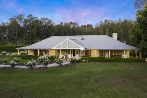 a large yellow house with a large yard at Thistle Hill Guesthouse - walk to many wineries and restaurants in Pokolbin