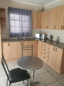 a kitchen with a table and a table and chair at Funky Dot Sleeping Spot in Kempton Park