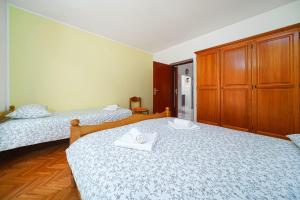 1 dormitorio con 2 camas y armario de madera en Apartment Bojic, en Vodice