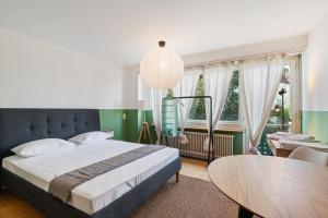 Schlafzimmer mit einem Bett, einem Tisch und Stühlen in der Unterkunft Central Lucerne Apartments in Luzern