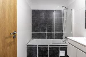 a bathroom with a bath tub and a sink at Rochato Dreams in Portimão +11 photos
