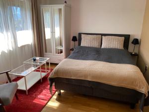 Apartment „AlpView“,Tirol mit Sauna und Pool في Vomp: غرفة نوم بسرير وطاولة زجاجية