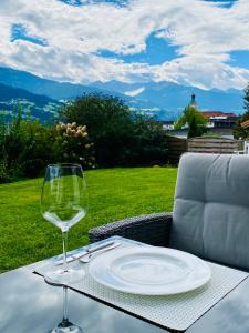 Apartment „AlpView“,Tirol mit Sauna und Pool في Vomp: طاولة مع صحن وكأس من النبيذ