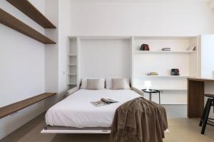 Schlafzimmer mit einem Bett mit weißen Wänden und Regalen in der Unterkunft Contempora Apartments - Cermenate 54B in Mailand