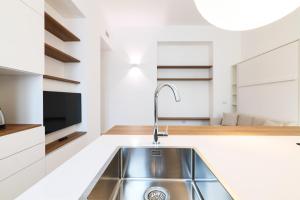 eine Küche mit einem Waschbecken und einem TV in der Unterkunft Contempora Apartments - Cermenate 54B in Mailand