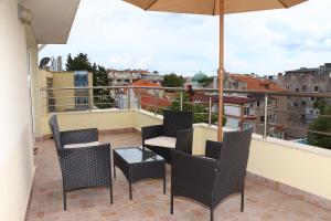 a patio with chairs and an umbrella on a balcony at Shik & Chic in the Heart of Burgas # 5min from beach # New in Burgas City
