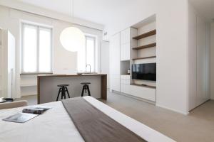 ein weißes Schlafzimmer mit einem großen Bett und einer Küche in der Unterkunft Contempora Apartments - Cermenate 54B in Mailand