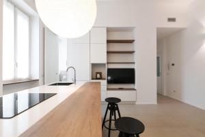 eine Küche mit einer Holztheke und einer großen Leuchte in der Unterkunft Contempora Apartments - Cermenate 54B in Mailand