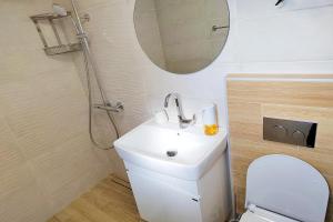 a bathroom with a toilet and a sink and a mirror at Shik & Chic in the Heart of Burgas # 5min from beach in Burgas City +57 photos