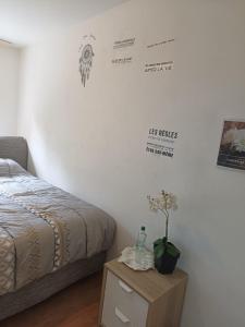 ein Schlafzimmer mit einem Bett und einem Tisch mit einer Flasche in der Unterkunft habitación en piso compartido in Yverdon-les-Bains