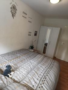 uma cama com um urso de peluche sentado em cima dela em habitación en piso compartido em Yverdon-les-Bains