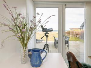 um vaso de flores sobre uma mesa com uma câmera em 5 person holiday home in Frederikshavn em Frederikshavn