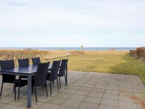 uma mesa e cadeiras num pátio com vista para o oceano em 5 person holiday home in Frederikshavn em Frederikshavn