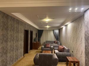 Habitación con 3 sofás, sofá y mesa. en Jouhayna Hotel&Suite, en Erbil