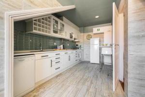 a kitchen with white cabinets and a sink at Large family flat in Campo de Ourique in Lisbon