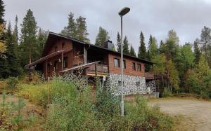 a large wooden house in the middle of a forest at Kärpänrinne A in Syöte