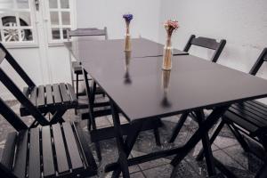 uma mesa com quatro cadeiras e dois vasos com flores em Click Apê Centro Foz em Foz do Iguaçu