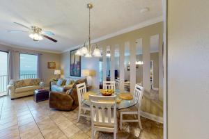 Una sala de estar y un comedor con mesa y sillas. en Phoenix V 1213, en Orange Beach
