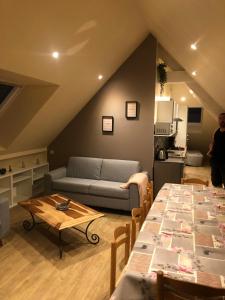 a living room with a couch and a table at Logement @ 10 personnes avec piscine intérieure 31 degrés zoo de la FLECHE 24 h du Mans in La Flèche