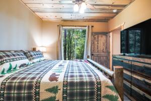 a bedroom with a bed and a flat screen tv at Lofty Escape in Ellijay