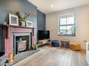 a living room with a fireplace and a tv at Gwrlodde in Talgarth