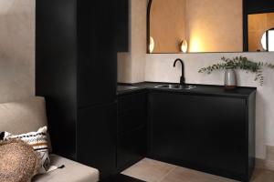 Baño negro con lavabo y espejo en Edificio Lola 3, en Lucena