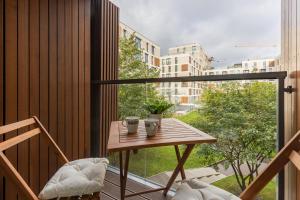 a balcony with a wooden table and a window at Warsaw Wola Apartment near Nocny Market by Noclegi Renters in Warsaw +24 photos