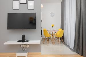 a dining room with a table and yellow chairs at Warsaw Wola Apartment near Nocny Market by Noclegi Renters in Warsaw