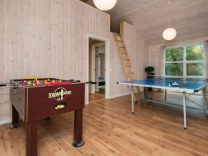 una mesa de ping pong en una habitación con una pelota de ping pong en 12 person holiday home in R m en Rømø Kirkeby