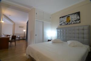 
a hotel room with a white bed and white walls at Duas Torres Hotel in Funchal
