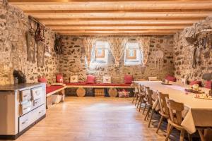 a kitchen with a long table in a room with stone walls at Oberwieserhof App 1 in San Lorenzo di Sebato